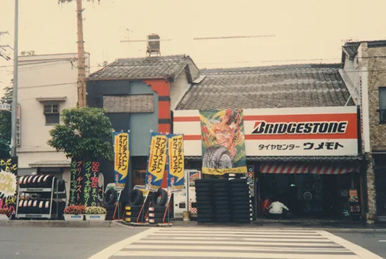 大野木ゴム工業所（現・ミスタータイヤマンウメモト京都駅前）を先代より譲り受ける。後の山科店オープンに伴い、タイヤセンターウメモト七条店となる。